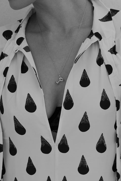 Odkryj nasz wyjątkowy naszyjnik od UMIAR biżuteria, zainspirowany kształtem kieliszka do martini, stworzony z myślą o otwarciu Jewellery Bar - ekskluzywnego butiku marki, łączącego wyjątkowy design z atmosferą barową. Jego głównym elementem jest naturalna perła, nawiązująca do charakterystycznej oliwki w tym popularnym drinku. Długość łańcuszka wynosi 50 cm. Całkowicie wykonany ręcznie ze szlachetnych materiałów: srebra 925 oraz srebra 925 pozłacanego 24-karatowym złotem.