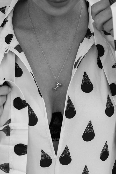 Odkryj nasz wyjątkowy naszyjnik od UMIAR biżuteria, zainspirowany kształtem kieliszka do martini, stworzony z myślą o otwarciu Jewellery Bar - ekskluzywnego butiku marki, łączącego wyjątkowy design z atmosferą barową. Jego głównym elementem jest naturalna perła, nawiązująca do charakterystycznej oliwki w tym popularnym drinku. Długość łańcuszka wynosi 50 cm. Całkowicie wykonany ręcznie ze szlachetnych materiałów: srebra 925 oraz srebra 925 pozłacanego 24-karatowym złotem.