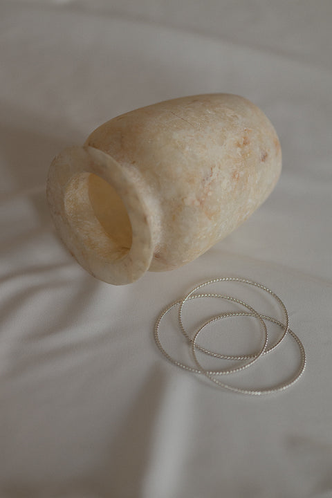 Odkryj elegancję z UMIAR biżuteria! Potrójna bransoletka typu bangle ze srebra, subtelnie fakturowana motywem splecionej liny, to ponadczasowy klasyk w nowoczesnym wydaniu. Idealna do codziennych i wieczorowych stylizacji. Z kolekcji AMORE – symbol spotkania serc. Dodaj wyjątkowy akcent do swojej kolekcji!