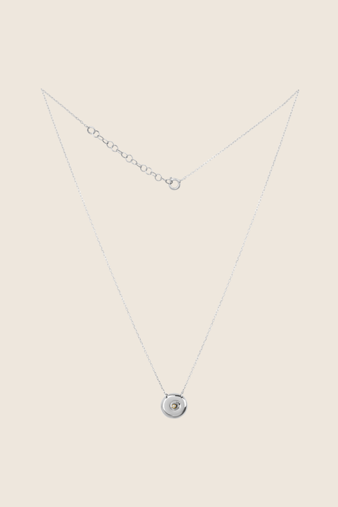Odkryj elegancki naszyjnik-celebrytkę z naturalnym diamentem od UMIAR biżuteria, wykonany ręcznie ze srebra próby 925. Unikalny, okrągły dysk z zagłębioną kuleczką łączy ponadczasowy styl z nowoczesnym wyrazem, symbolizując kobiecość, bliskość i cykle życia. Idealny prezent na wyjątkowe okazje – kup teraz!