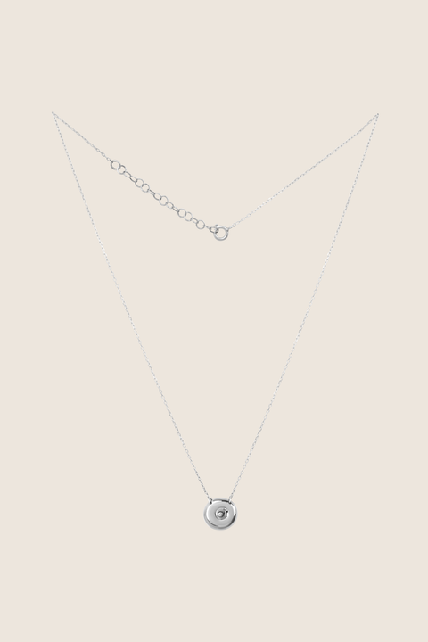Odkryj elegancki naszyjnik-celebrytkę z naturalnym diamentem od UMIAR biżuteria, wykonany ręcznie ze srebra próby 925. Unikalny, okrągły dysk z zagłębioną kuleczką łączy ponadczasowy styl z nowoczesnym wyrazem, symbolizując kobiecość, bliskość i cykle życia. Idealny prezent na wyjątkowe okazje – kup teraz!