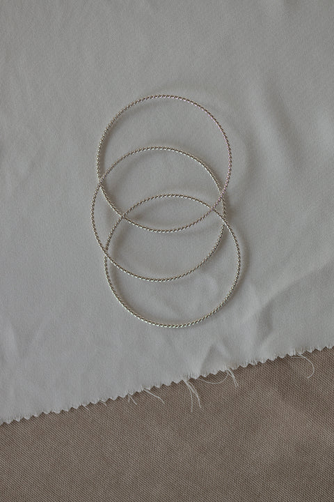 Odkryj elegancję z UMIAR biżuteria! Potrójna bransoletka typu bangle ze srebra, subtelnie fakturowana motywem splecionej liny, to ponadczasowy klasyk w nowoczesnym wydaniu. Idealna do codziennych i wieczorowych stylizacji. Z kolekcji AMORE – symbol spotkania serc. Dodaj wyjątkowy akcent do swojej kolekcji!