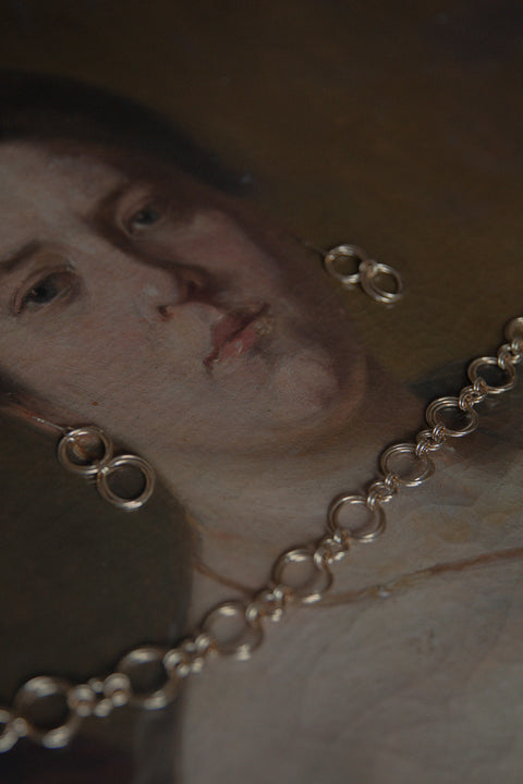 Podkreśl swój wyjątkowy styl dzięki naszemu chokerowi typu łańcuch z kolekcji WIĘZI UMIAR biżuteria. Wykonany ręcznie z setek delikatnych ogniw, ten choker emanuje elegancją i subtelnością. Z długością 42 cm doskonale dopasowuje się do szyi, dodając niepowtarzalnego uroku każdej stylizacji. Dostępny w dwóch wariantach: srebrze 925 oraz srebrze 925 pozłacanym 24-karatowym złotem, ten model to połączenie tradycyjnych rzemieślniczych technik z nowoczesnym wzornictwem.