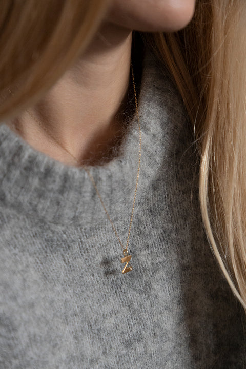 Subtelny wisiorek na łańcuszku w kształcie litery Z, inkrustowany brylantem o masie 0,007 ct (1,2 mm). Ten elegancki naszyjnik jest idealnym dodatkiem do każdej stylizacji, podkreślając delikatność i wyrafinowany styl. Wykonany z najwyższej jakości materiałów, zapewnia trwałość i blask przez długi czas. Długość łańcuszka wynosi 50 cm, co sprawia, że wisiorek idealnie układa się na dekolcie. Dodaj subtelny akcent do swojej biżuterii z tym wyjątkowym wisiorkiem z literą Z i brylantem.