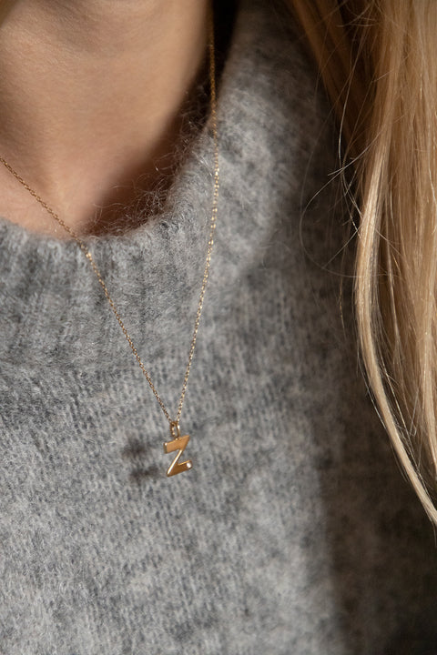 Subtelny wisiorek na łańcuszku w kształcie litery Z, inkrustowany brylantem o masie 0,007 ct (1,2 mm). Ten elegancki naszyjnik jest idealnym dodatkiem do każdej stylizacji, podkreślając delikatność i wyrafinowany styl. Wykonany z najwyższej jakości materiałów, zapewnia trwałość i blask przez długi czas. Długość łańcuszka wynosi 50 cm, co sprawia, że wisiorek idealnie układa się na dekolcie. Dodaj subtelny akcent do swojej biżuterii z tym wyjątkowym wisiorkiem z literą Z i brylantem.