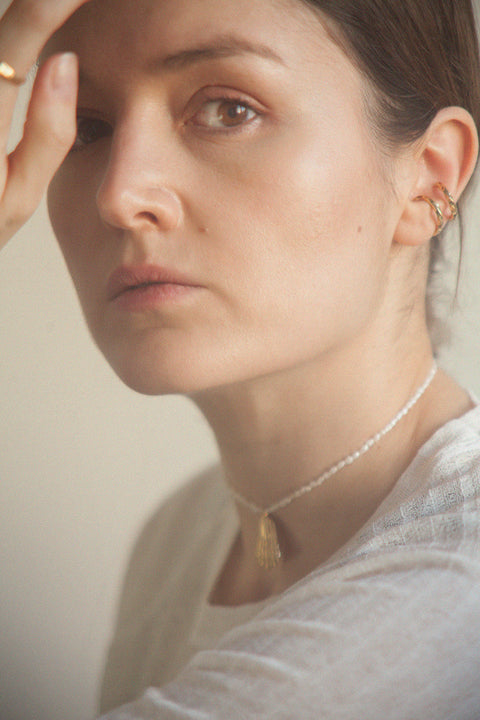 Wyjątkowy naszyjnik choker, stworzony z połączenia srebrnego łańcuszka, delikatnego wisiorka w kształcie połamanej muszli i naturalnych pereł. Regulowana długość łańcuszka pozwala nosić go przy szyi lub nieco niżej. Ręcznie wykonany ze szlachetnych materiałów przez UMIAR biżuteria. Dostępny w dwóch wariantach: srebrze 925 i srebrze 925 pozłacanym 24-karatowym złotem.